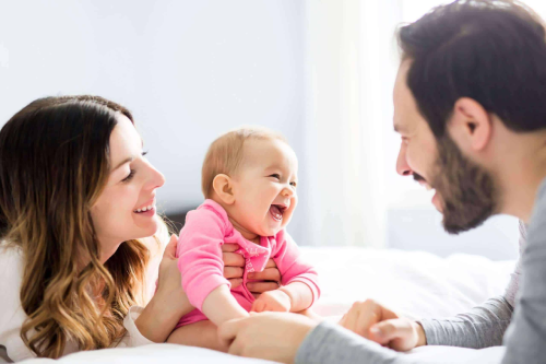 family smiling with baby